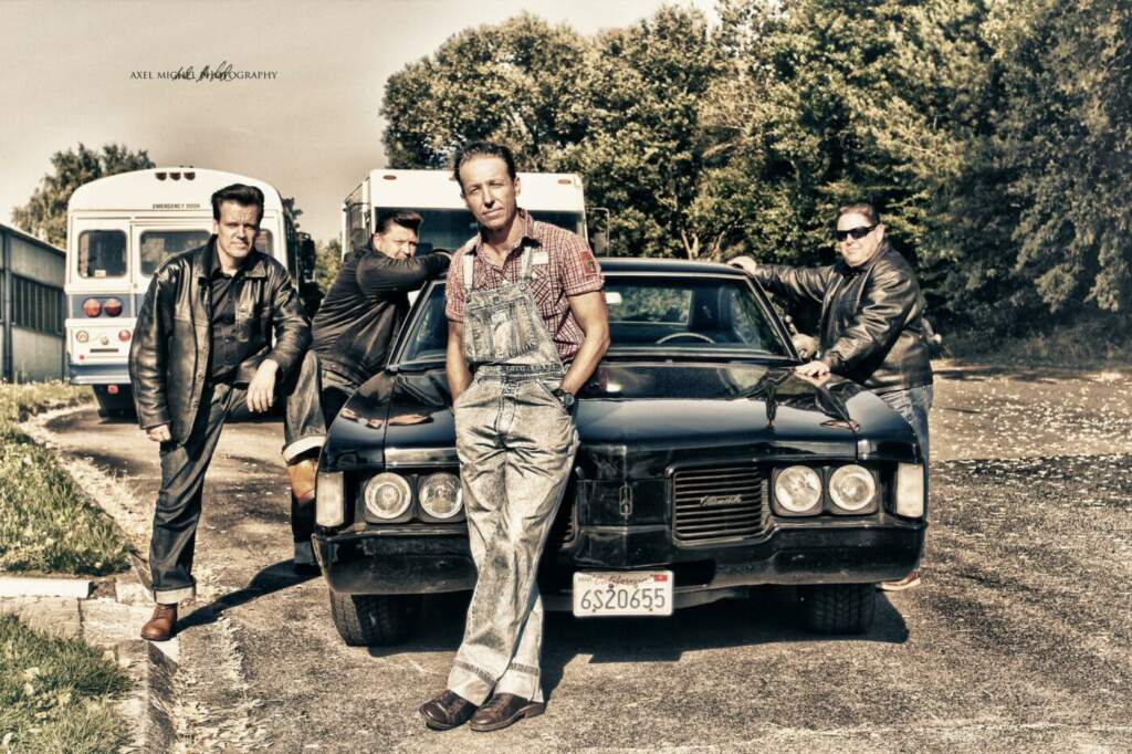 Vier Männer in Rockabilly-Mode posieren vor Oldtimer Die Boptown Cats sind wieder Teil des Programm vom Marburger Hafenfest! | (c) Boptown Cats