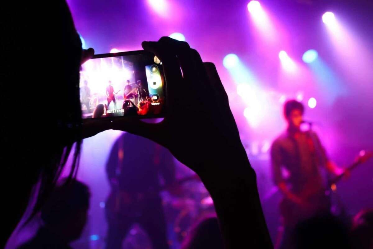 Eine Frau ist auf einem Konzert und filmt den Auftritt mit ihrem Handy, Kostenlos, Werbung, Veranstaltungen, Events, Konzerte, Festivals, Musicals, Musiker, Bands, Stadtfeste, Open Air, Veranstalter, gebührenfrei Konzerte kostenfrei bewerben und veröffentlichen! - Kostenlose Werbung für Konzerte, Festivals, Musicals, Stadtfeste, Musiker, Bands etc.