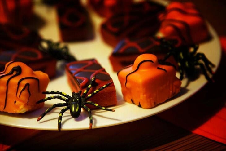 Halloween-Gebäck mit Spinnen-Dekoration auf einem Teller, Süßes oder Saures, Halloween, Fest Süßes oder Saueres? Viele Menschen finden, Halloween habe seine Tradtition verloren und sei zum Konsumfest geworden.