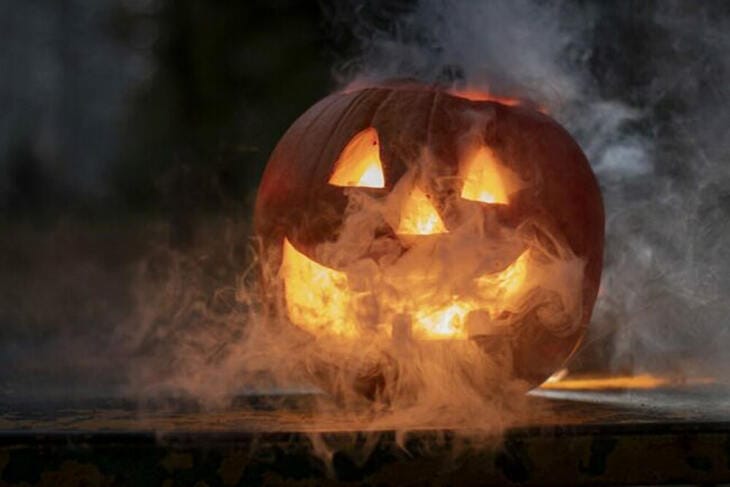 Gruselige Halloween-Kürbislaterne mit Rauch und leuchtendem Gesicht im Dunkeln, Halloween, Laterne, Events, Symbol Der geschnitzte Kürbis ist das bekannteste Halloween-Symbol: ausgehölt als Laterne wird er "Jack O’Lantern" genannt