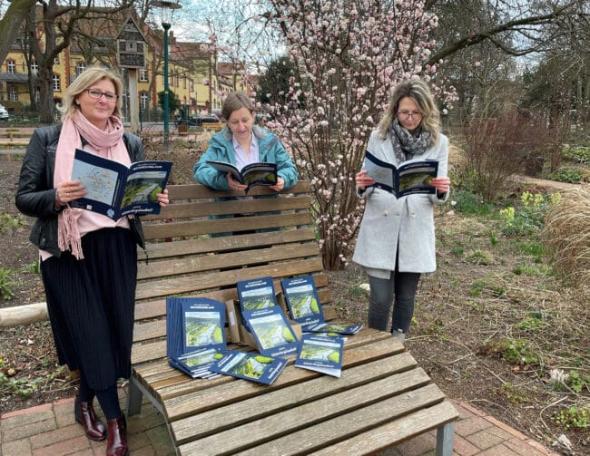 Die Geschäftsführerin des Weserbergland Tourismus e.V. Petra Wegener sowie die Projektmanagerinnen Jessica Dolle und Sina Scholz sind bereits in das neue Reisemagazin ≫Meine Weserberglandzeit≪ vertieft. | (c) Weserbergland Tourismus e.V.