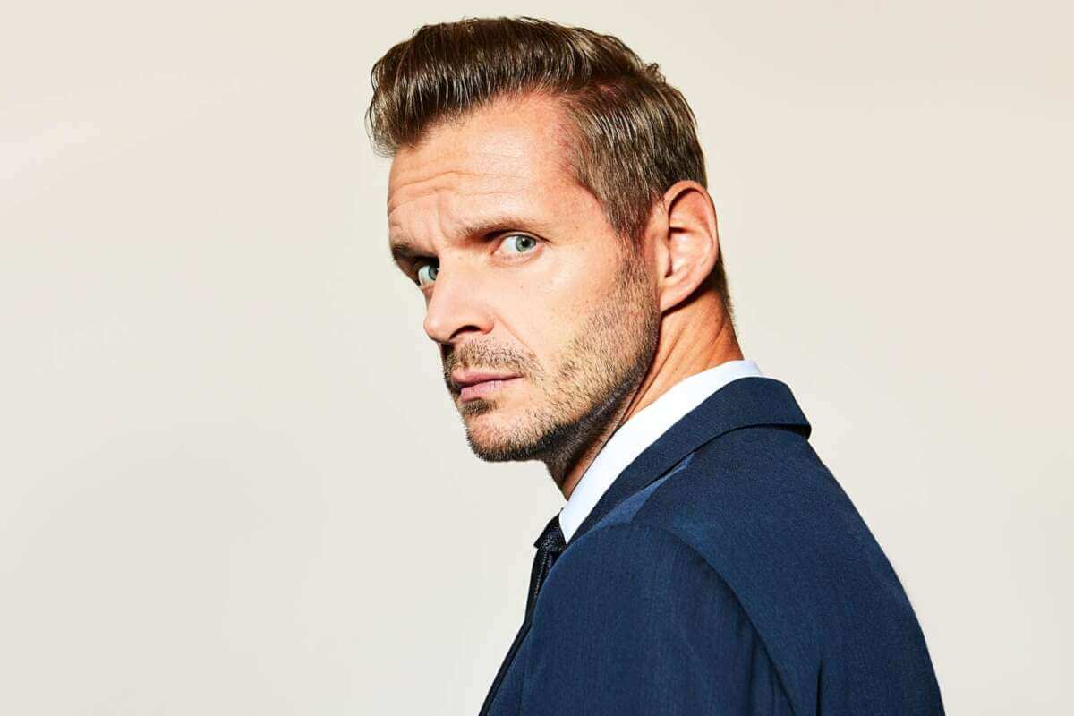 Scharfer Blick, klare Haltung: Kabarettist Florian Schroeder zeigt sich im eleganten Anzug im Halbprofil und schaut direkt in die Kamera. Das reduzierte Porträt unterstreicht seine pointierte Bühnenpräsenz – passend zum Programm beim „Sommer im Park 2026“ in Vellmar, wo Wortwitz und Zeitgeist aufeinandertreffen. Florian Schroeder (c) Frank-Eidel Quer