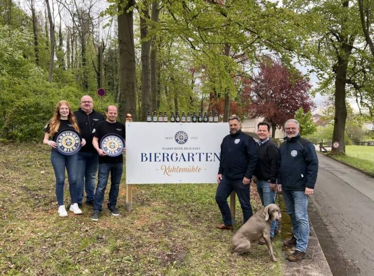 Biergarten, Kuhlemühle, Warburger Brauerei, Livemusik, Veranstaltungen Das Schild zum Biergarten der Warburger Brauerei ist neu, dahinter steckt dasselbe Team. Holger Schütze, Pächter des Biergartens Kuhlemühle, mit seinen Mitarbeitern Fiona Kropp und Michael Tewes. Braumeister Peter Schießl (rechts, Mitte) mit den Brauereichefs Franz-Axel Kohlschein und Michael Kohlschein. | (c) Foto Valeria Geritzen