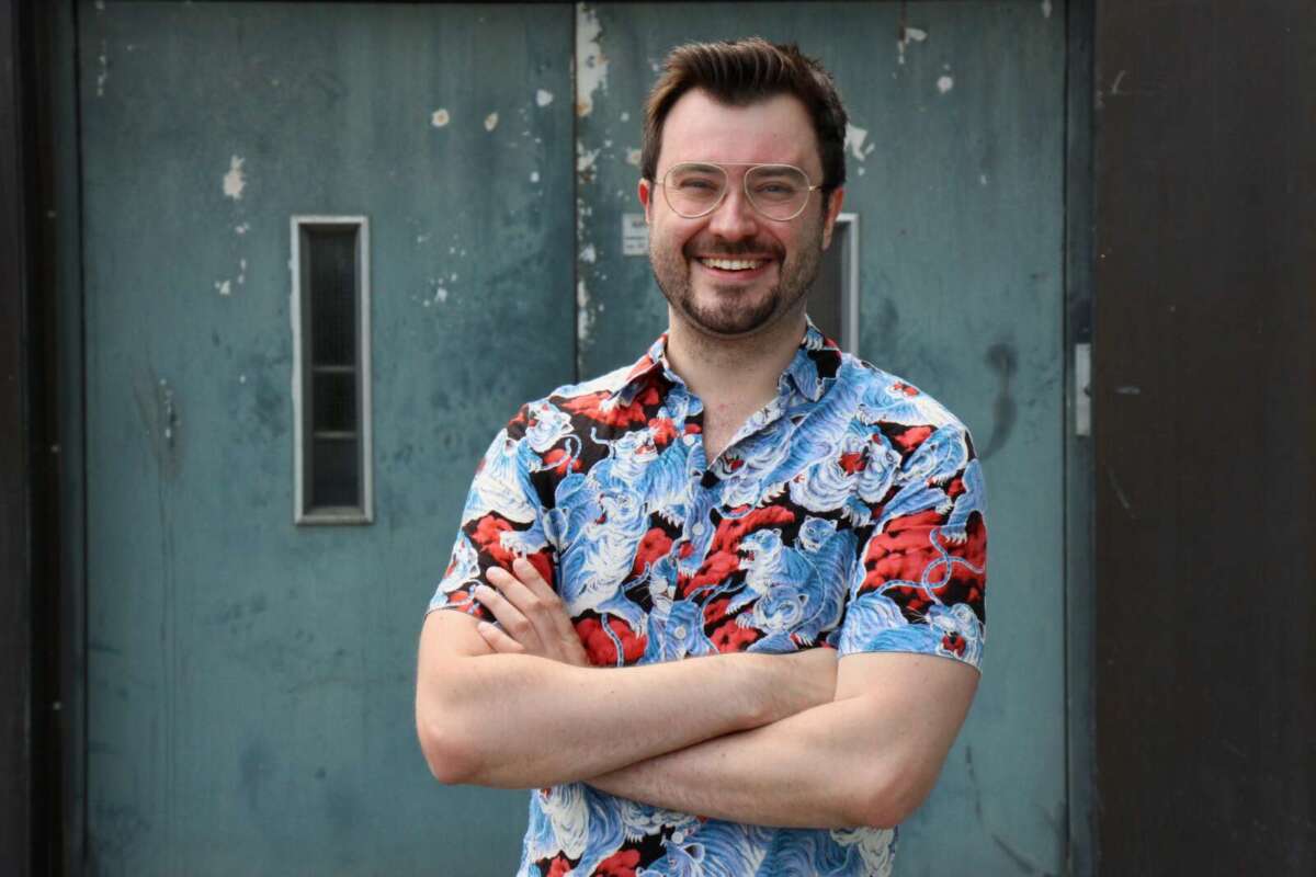 Sebastian Klussmann hat die Arme verschränkt und lächelt in die Kamera. Er trägt ein bunt gemustertes Hemd Quizchampion Sebastian Klussmann bekannt durch die ARD- Quizshow »Gefragt-Gejagt« hält beim Kultursommer Nordhessen einen Vortrag | (c) Lukas Maderner