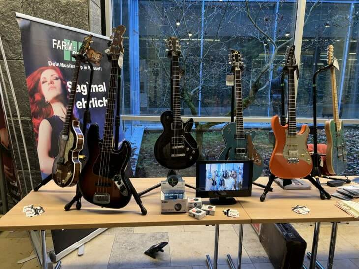 Auf einem Tisch stehen viele verschiedene Gitarren, kleine Gitarrenauswahl, Gitarrenfestival Edersee Farm Sound - Kleine Gitarrenauswahl - Mehr beim Gitarrenfestival Edersee | (c) Armin Engelhard