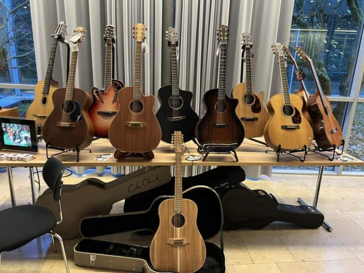 Auf einem Tisch und auf dem Boden stehen viele verschiedene Gitarren, unter dem Tisch sind die Gitarrenkoffer, kleine Gitarrenauswahl, Gitarrenfestival Edersee Farm Sound - Kleine Gitarrenauswahl - Mehr beim Gitarrenfestival Edersee | (c) Armin Engelhard