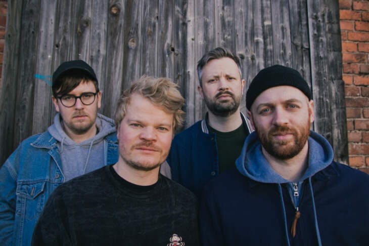 Die Band Kyles Tolone posiert vor einer Holzwand für das Heartbeat Festival 2024 in Bad Hersfeld, Kyles Tolone Bandfoto, Heartbeat Festival 2024 Bad Hersfeld, Benefizkonzert für den guten Zweck Auch Kyles Tolone kommen nach Meinbrexen zum Heartbeat Festival- Pressefoto- 2022 - (c) Isabelle Kaltner