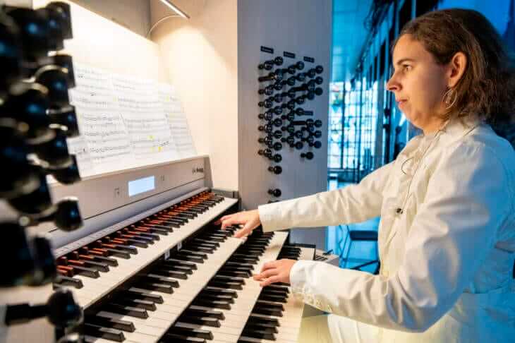 Ines Schüttengruber spielt eine Orgel in einem gut beleuchteten Raum, während sie in ein Notenblatt blickt. Ines Schuettengruber kommt zu den Kasseler Musiktage 2024 | (c) KMT - Bernd Schoelzchen