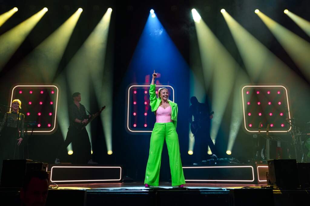 Beatrice Egli in neonfarbenem Outfit auf der Bühne mit Band, Weser Open Air 2025 in Beverungen Beatrice Egli geht live immer ab. Davon können sich die Besucher des Weser Open Air 2025 in Beverungen bald persönlich überzeugen. | (c) Anelia Janeva Gros