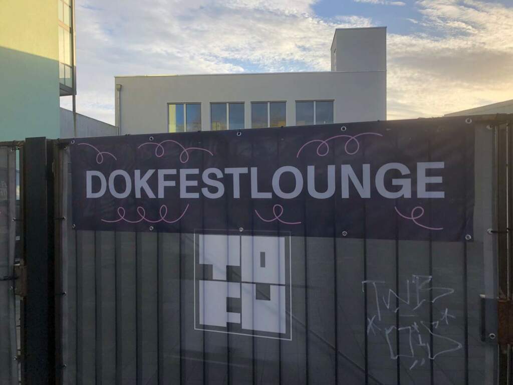 Eingangstor der Dokfestlounge mit dekorativem Banner bei Tageslicht