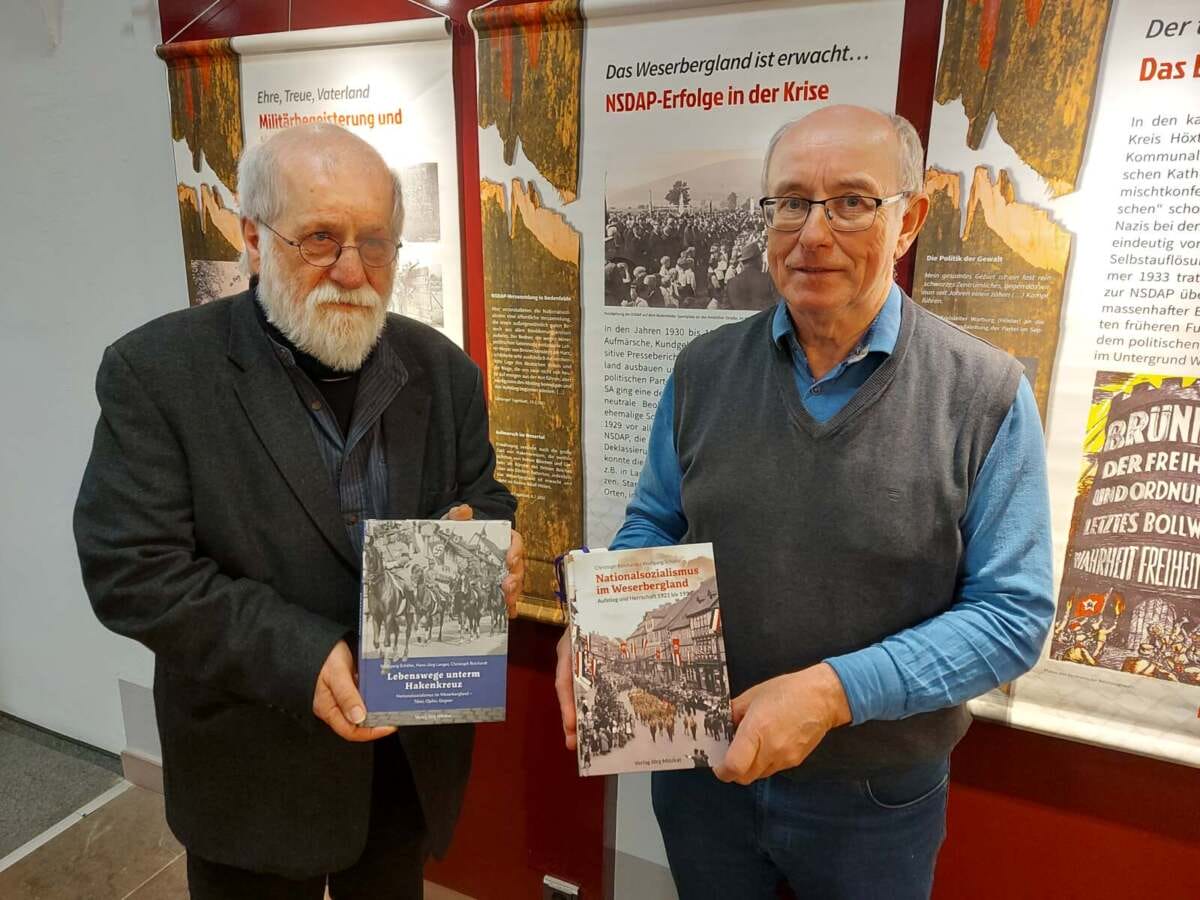 Zwei Männer zeigen Bücher zur NS-Geschichte im Museum, Dr. Wolfgang Schäfer, Stadtarchivar und Museumsleiter in Uslar und Christoph Reichardt, Stadtheimatpfleger von Beverungen halten Bücher zur Geschichte der Nationalsozialisten in den Händen „Bürgerkrieg im Wesertal“: Dr. Wolfgang Schäfer (links), Stadtarchivar und Museumsleiter
in Uslar, sowie Christoph Reichardt, Stadtheimatpfleger von Beverungen, werfen ein Licht
auf das dunkelste Kapitel deutscher Geschichte. Sie zeichnen die politische Geschichte
der Region in den 1920er- und 1930er-Jahren nach und gehen auf die
bürgerkriegsähnlichen Verhältnisse ein, die zeitweilig in Bad Karlshafen, Beverungen,
Höxter, Hofgeismar und Holzminden herrschten | (c) Kreis Höxter