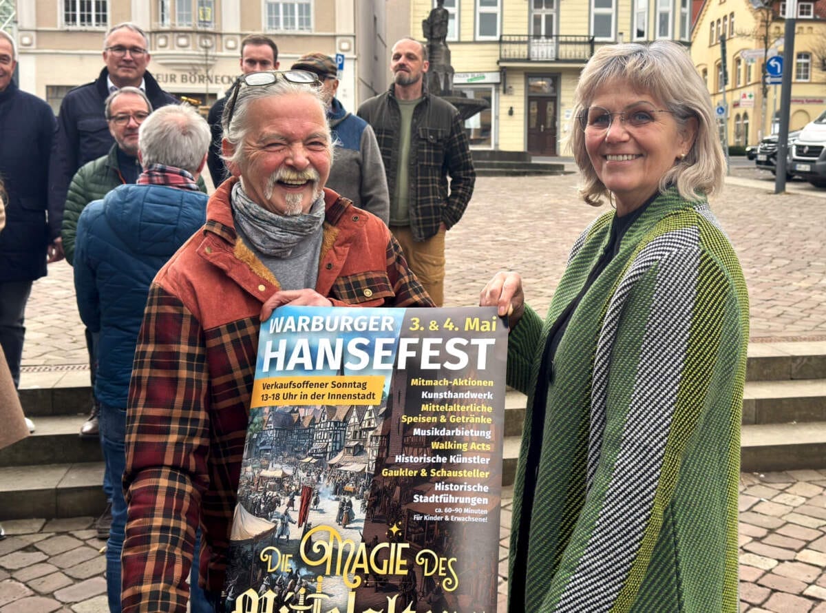 Zwei Personen halten Plakat für das Warburger Hansefest 2025 Simone und Jürgen Wiedemeier präsentieren, sichtlich gutgelaunt und voller Vorfreude, das Plakat für das neue »Warburger Hansefest« | (c) Wildwechsel