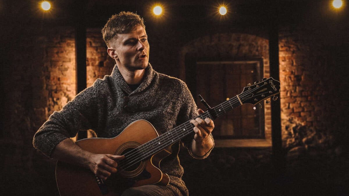 Andrej Vilcnik spielt Gitarre vor warm beleuchtetem Hintergrund. Andrej Vilčnik aus Slowenien vertritt seine Stadt beim Marburger StäPs-Festival 2025 | (c) Andrej Vilčnik