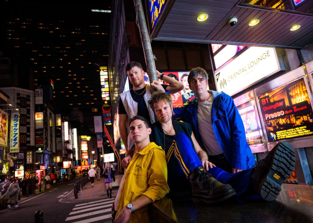 Enter Shikari posiert nachts in Tokios Neonlicht-Szenerie Von Tokio nach Eschwege: Enter Shikari bringen ihre explosive Liveshow und genreübergreifenden Sound aufs Open Flair Festival 2025: | (c) Lukaz Palka