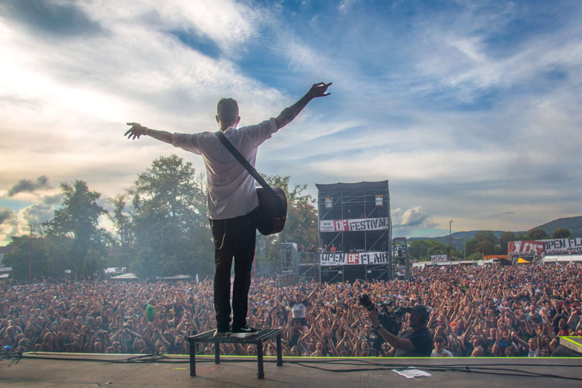 Gitarrist auf Bühne beim Open Flair Festival 2024 vor Menschenmenge Ausblick mit Wirkung: Über 20.000 Besucher:innen feiern jedes Jahr ausgelassen beim Open Flair 2024 – hier ein Moment von der Bühne aus gesehen. | (c) Sonja Berg