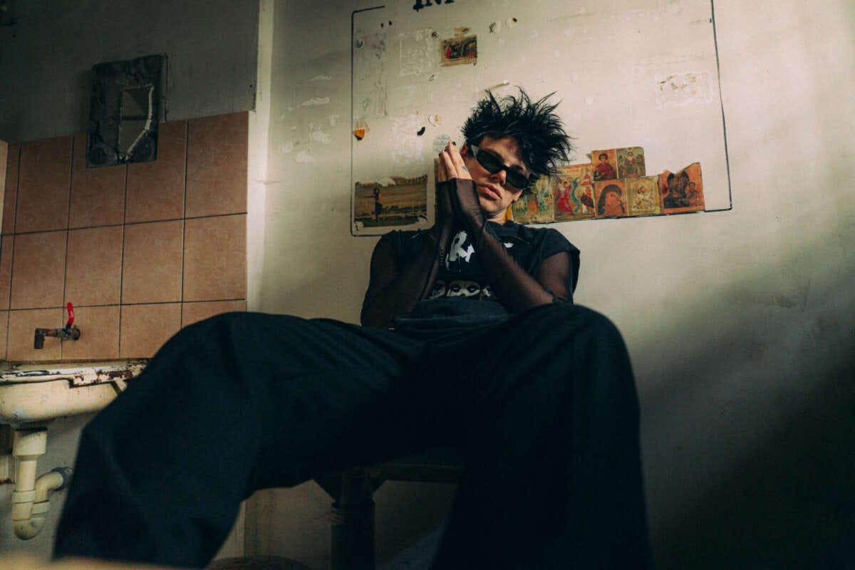 Yungblud sitzt lässig im düsteren, urbanen Raum Yungblud | (c) Vilnius