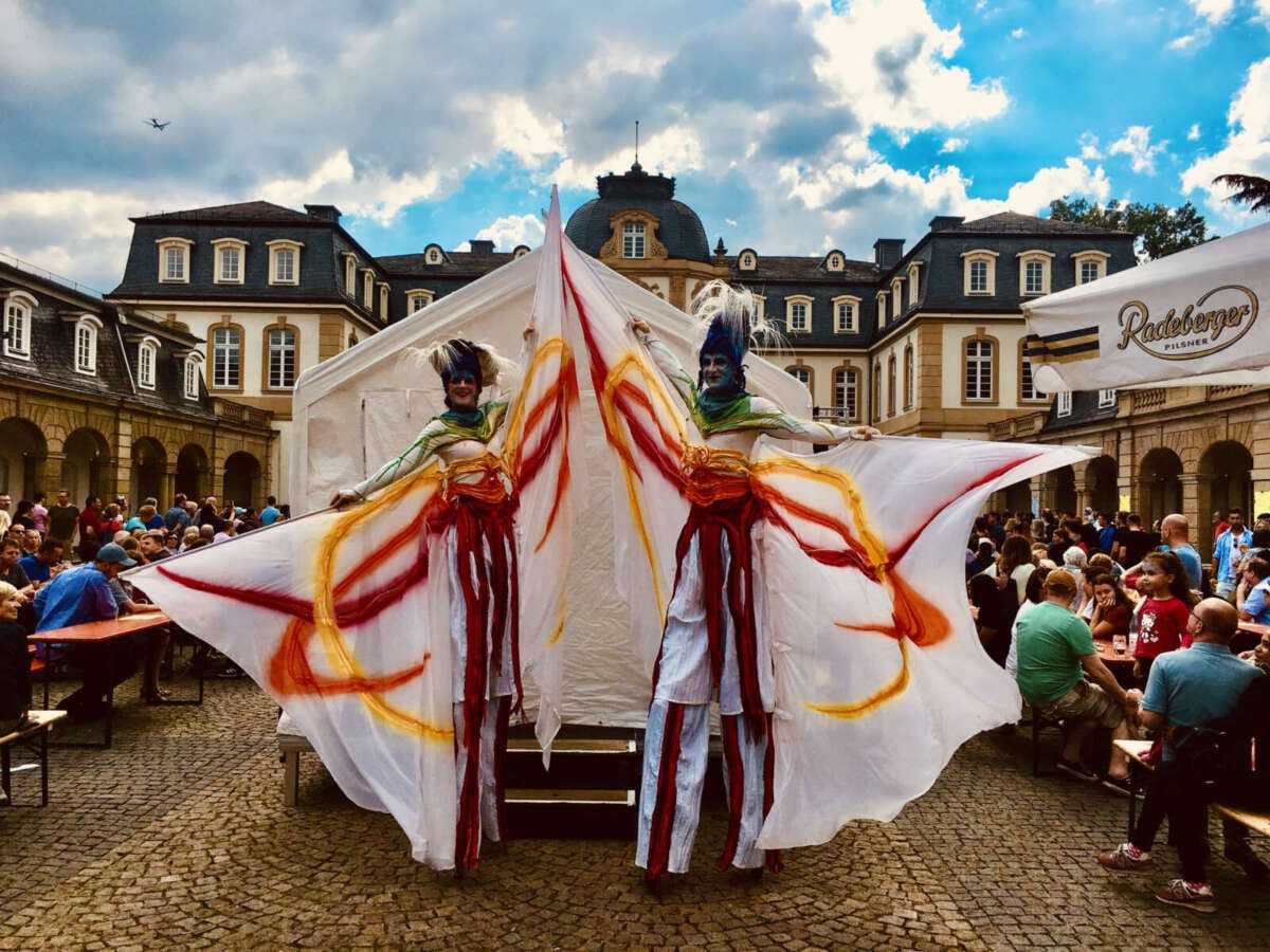 Zwei Stelzenkünstler mit bunten Kostümen auf Stadtfest Auch die Künstlerinnen von GAGE-Stelzenkunst sind Teil des Programm vom Wasser- & Lichterfest in Nieder-Werbe | (c) Gesine Habermann