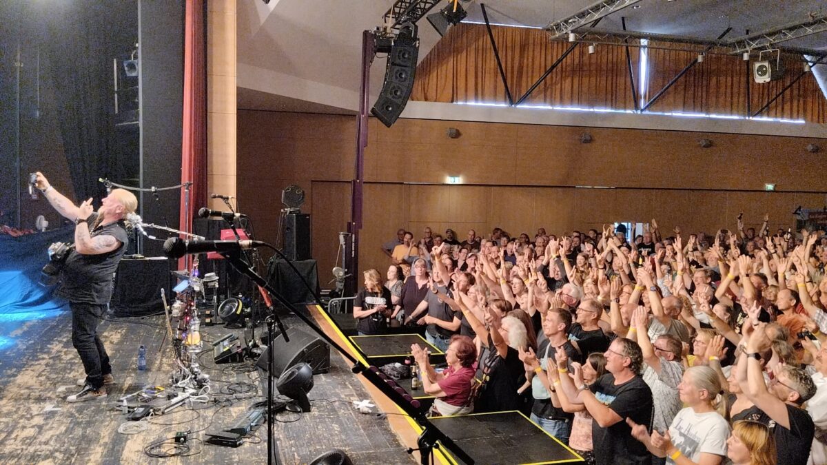Mike Gerhold nutzt den Moment – das Publikum in Willingen reagiert begeistert. Bereits beim Support-Set war klar: Dieser Abend wird laut, nah und voller gemeinsamer Energie. | Mike Gerhold als Support bei The Hooters in Willingen | (c) Mike Gerhold