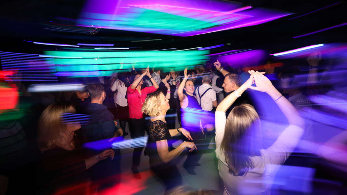 In Homburg beim HR Dancefloor leuchten bunte Neonlichter, während viele Menschen ausgelassen miteinander tanzen. hr-Dancefloor - homburg - 266 | (c) hr