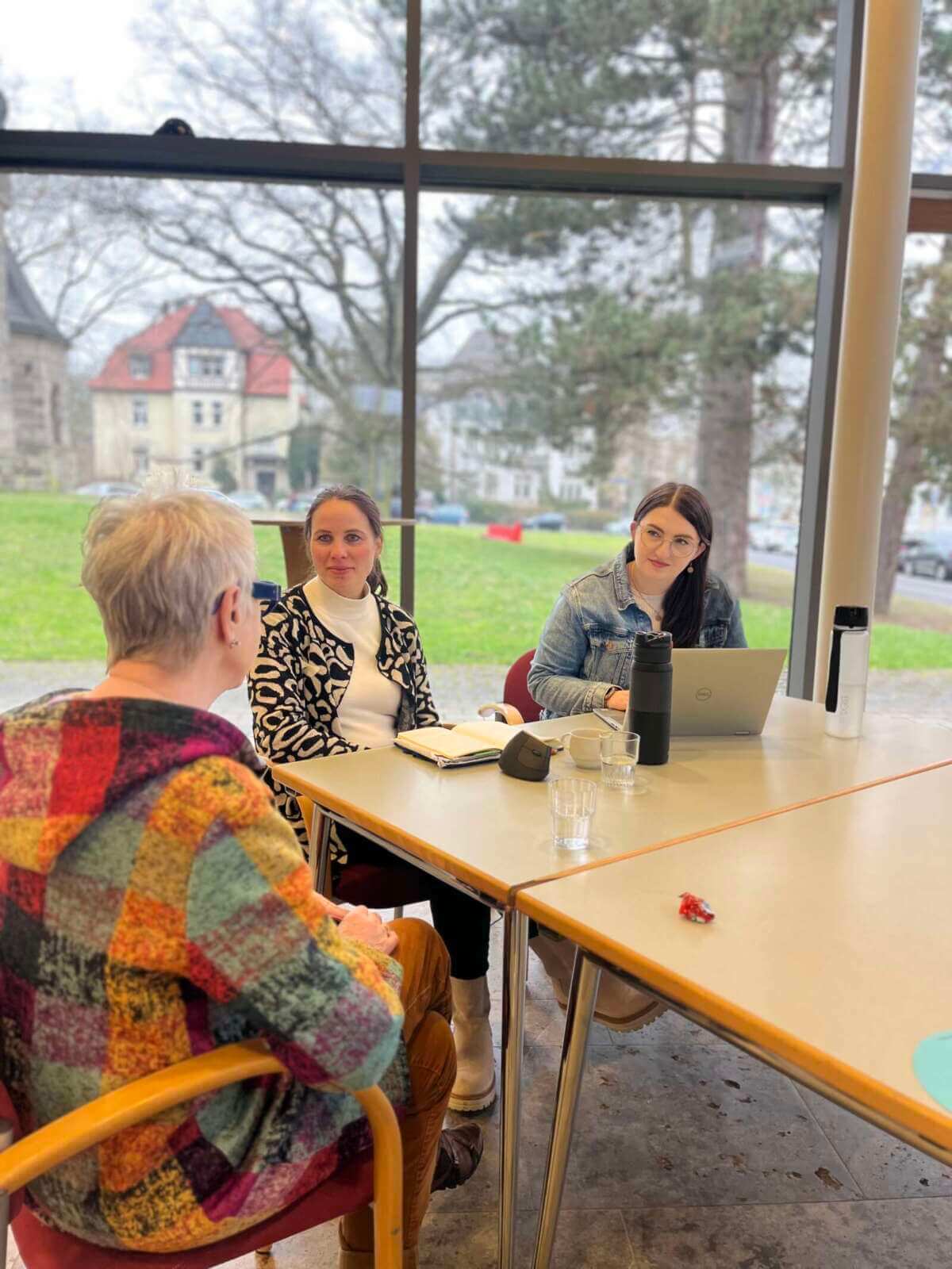 Bild vom letzten „Lass uns reden“-Format (Veranstaltung Haltestelle der Zukunft) eingefügt. Darauf zu sehen sind zwei NVV-Mitarbeiterinnen sowie eine Teilnehmerin (mit dem Rücken zugewandt) | (c) Nordhessischer VerkehrsVerbund (NVV)