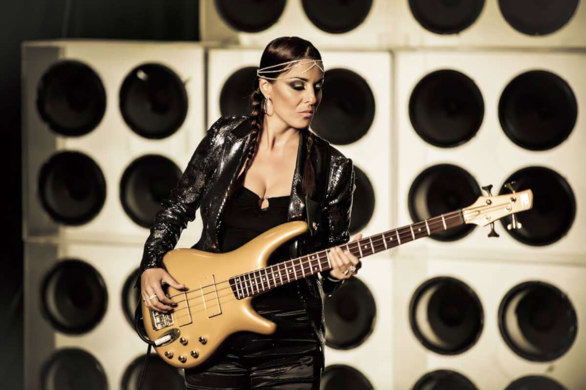 Die dänische Bassistin Ida Nielsen spielt vor einer Wand aus großen Lautsprecherboxen E-Bass und tritt mit ihrer Band The Funkbots im KFZ Marburg auf. | (c) NPGrecords