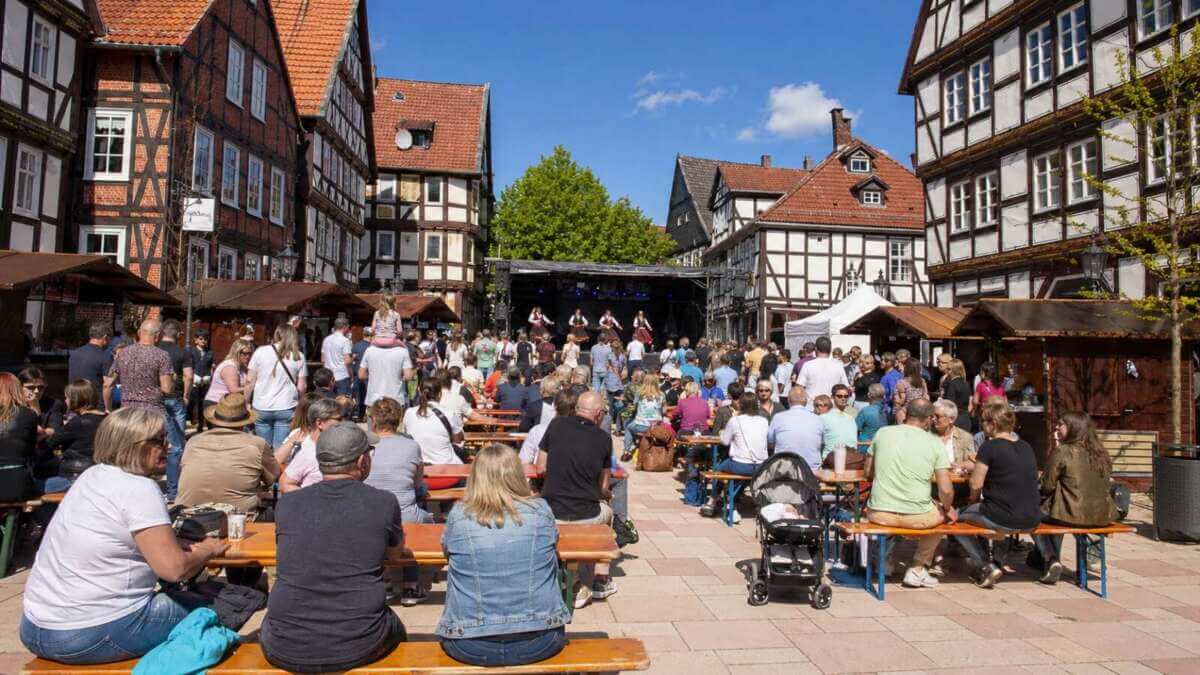 Zwischen Fachwerkhäusern und Marktständen wird das Dornröschenfest Hofgeismar zur Open-Air-Bühne: Zahlreiche Besucher verfolgen das Bühnenprogramm und genießen das gesellige Ambiente des beliebten Stadtfestes. Dornröschenfest Hofgeismar - KI generiert - (c) Wildwechsel