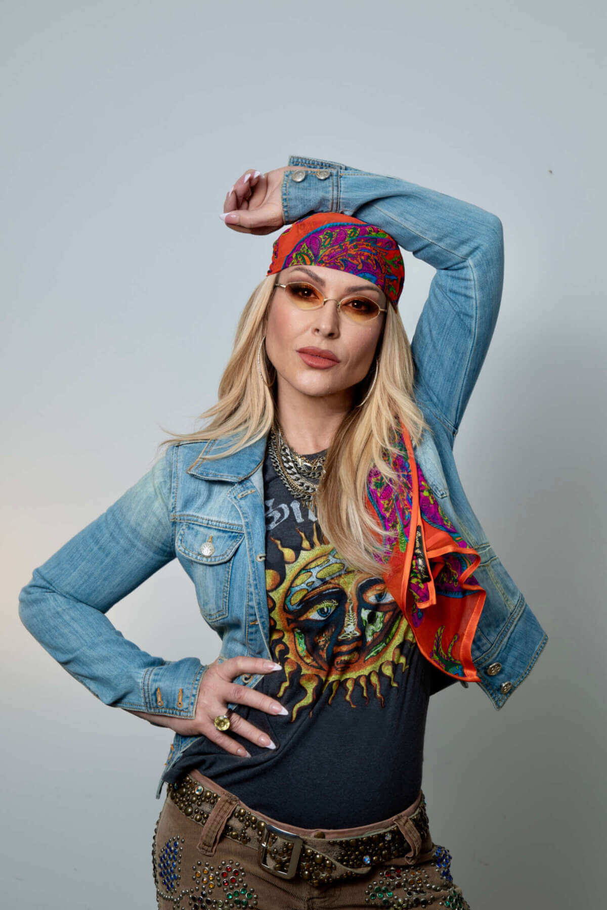 Das Bild zeigt Anastacia vor hellem Hintergrund. Sie trägt eine Jeansjacke, ein buntes Kopftuch, schmale Sonnenbrille und Schmuck und blickt selbstbewusst in die Kamera. Anastacia gehört zum Butzbach Open Air 2026 und posiert im auffälligen Look mit Jeansjacke, Sonnenbrille und Kopftuch. |(c) Lisa Hetzel