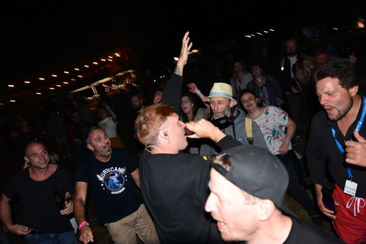 Sänger performt mitten im Publikum beim Kraut & Rüben Musikfestival in Hembsen, während Besucher begeistert mitsingen und die Open-Air-Atmosphäre genießen | (c) Andreas Rüther